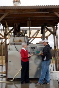 Dr. Jeanne Koger (left) checks on readings from equipment used in gasification, the process of burning animal waste and creating fuel grade ethanol. photo by Roger Winstead