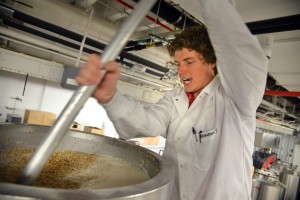 PhD candidate Brandon Jones stirs malt for the latest beer production run in a Schaub Hall lab.